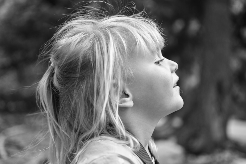 Black and white portrait of a young child smiling outdoors